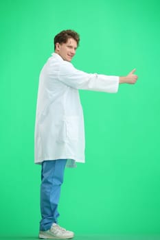 The doctor, in full height, on a green background, shows a thumbs up.