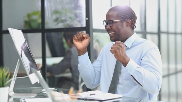 happy man working in the office. raised up his hands joyfully