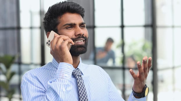 businessman talking on phone with customers, male salesman working inside modern office building.