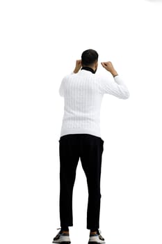 A man, full-length, on a white background, raised his hands up.