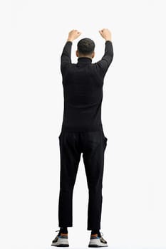 A man, full-length, on a white background, raised his hands up.