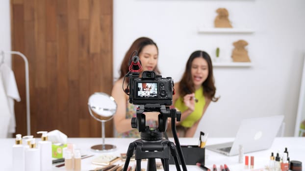 Two influencer partner shoot live streaming vlog video review makeup social media or blog. Happy young girl with vivancy cosmetics studio lighting for marketing recording session broadcasting online.