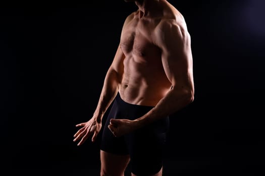 Handsome bodybuldier man posing showing muscle, shirtless torso showing pectorals and sixpacks