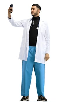 The doctor, in full height, on a white background, talking on the phone.