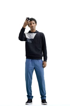 A man, full-length, on a white background, waving his phone.