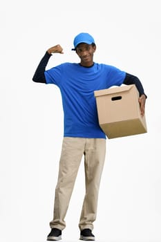 The deliveryman, in full height, on a white background, with a box, shows strength.