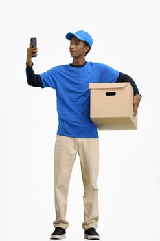 The deliveryman, in full height, on a white background, with a box, talking on the phone.