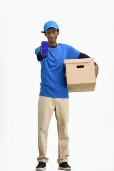 The deliveryman, in full height, on a white background, with a box, shows the phone.