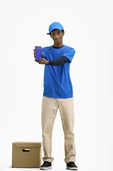 The deliveryman, in full height, on a white background, with a box, shows the phone.