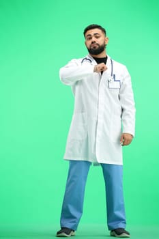 The doctor, in full height, on a green background, hits his chest.