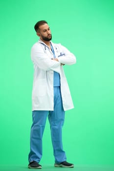 The doctor, in full height, on a green background, crossed his arms.