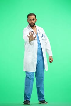 The doctor, in full height, on a green background, shows a stop sign.