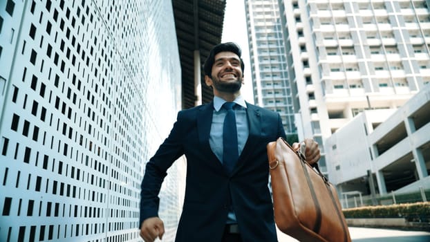 Skilled business man dancing with joyful while walking in city street. Project manger receive a good news, getting promotion, getting a successful job while express feeling of overjoy. Exultant.