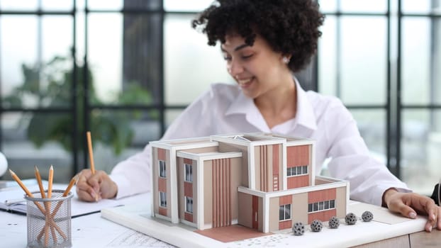 female architect designer examines house layout in office