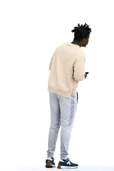 A man, full-length, on a white background, uses a phone.