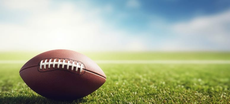 An American football placed on a green grass field with a bright and sunny sky in the background, symbolizing sports and outdoor activities.