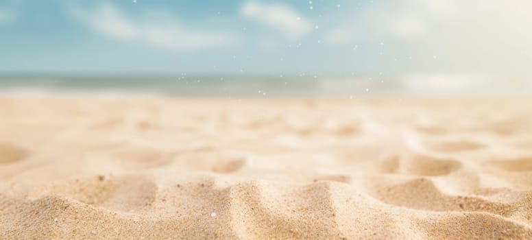 Close-up of a tranquil sandy beach with a soft-focus ocean in the background and particles glistening.