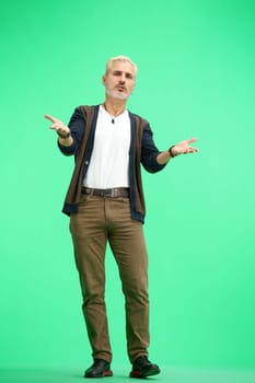 A man, full-length, on a green background, spreads his arms.