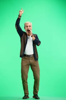 A man, full-length, on a green background, rejoices.