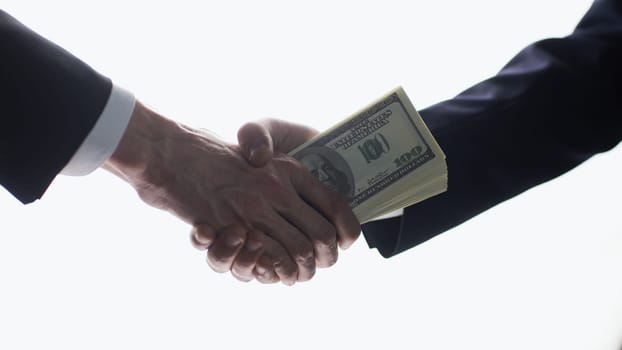 Businessmen's handshake and money transfer. Simple and effective approach. Be attentive with your partners.