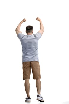 A man in a gray T-shirt, on a white background, in full height, raised his hands.