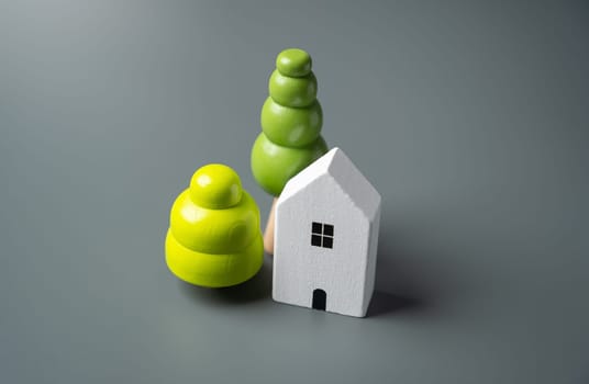 House and decorative trees, figurines. Housing prices. Buying and selling real estate.