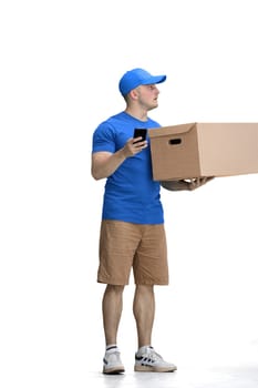 Male deliveryman, on a white background, full-length, with a phone and box.