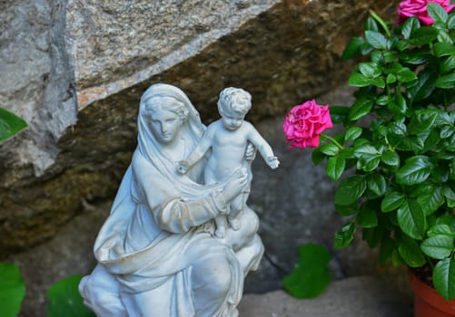 Stone statue of the virgin Mary carrying a baby