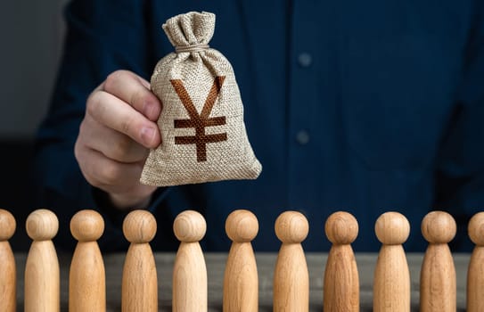A man holds a chinese yuan or japanese yen money bag above the crowd. Deposits and loans. Budgetary funds for social policy. Social politics. Salaries. Crowdfunding and fundraising.