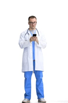 A male doctor, on a white background, in full height, uses a phone.