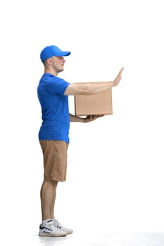 A male deliveryman, on a white background, in full height, with a box, shows a stop sign.