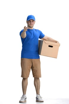A male deliveryman, on a white background, full-length, with a box, points up.