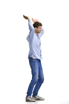 A man in a blue shirt, on a white background, in full height, raised his hands up.