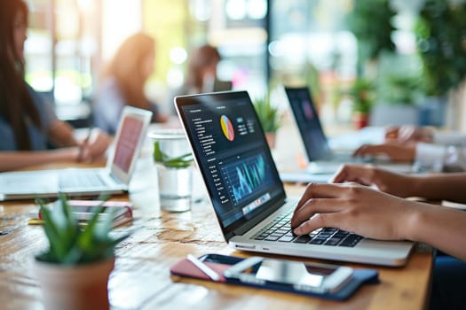 Person using a laptop with financial data with graphs and charts on a laptop computer at workplace.