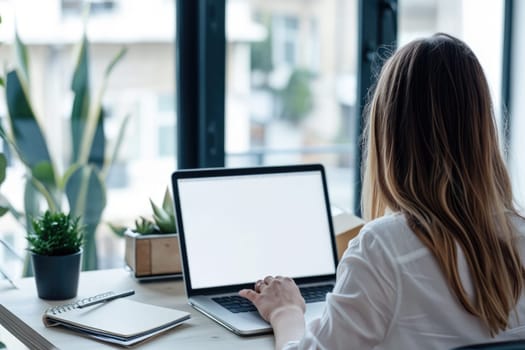 Mockup image of a woman using laptop and presenting with blank white screen for advertising text.