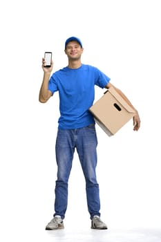 Male deliveryman, on a white background, full-length, with a phone and box.