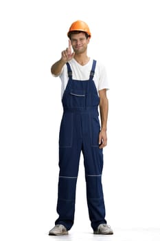 A male construction worker, on a white background, in full height, shows an important sign.