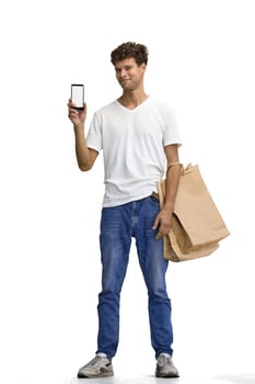 A man in a white T-shirt, on a white background, full-length, with bags and a phone.