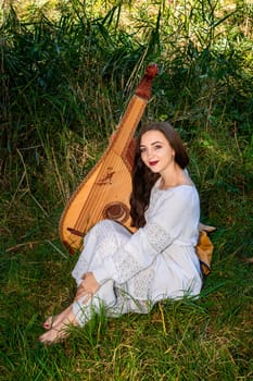 A young Ukrainian woman in a white dress. Ukrainian woman with bandura.