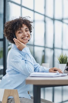 girl in a modern office working in a call center smiling.