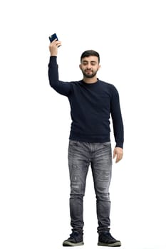 A man, full-length, on a white background, waving his phone.