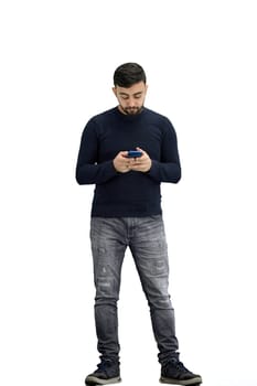 A man, full-length, on a white background, uses a phone.