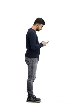 A man, full-length, on a white background, uses a phone.