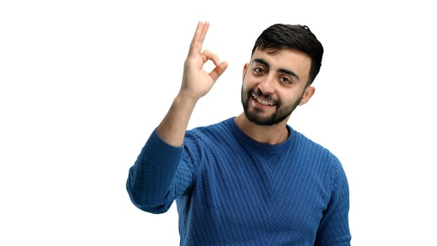 A man, close-up, on a white background, shows an ok sign.