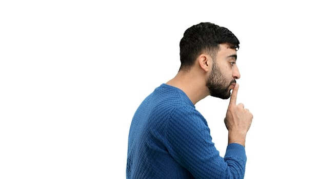 A man, close-up, on a white background, shows a sign of silence.