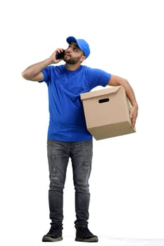 The deliveryman, in full height, on a white background, talking on the phone.