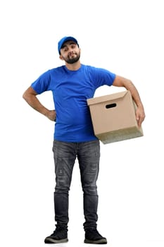 Delivery man, full-length, on a white background, with a box, hands on hips.