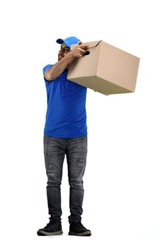 The deliveryman, in full height, on a white background, shakes the box.