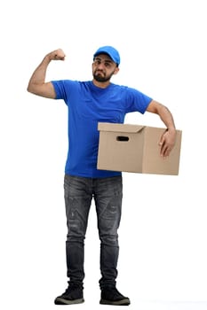 The deliveryman, in full height, on a white background, shows strength.