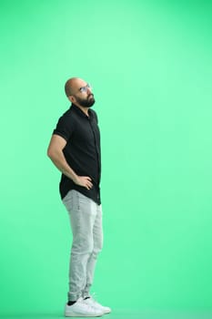 Man, on a green background, full-length, hands on hips.